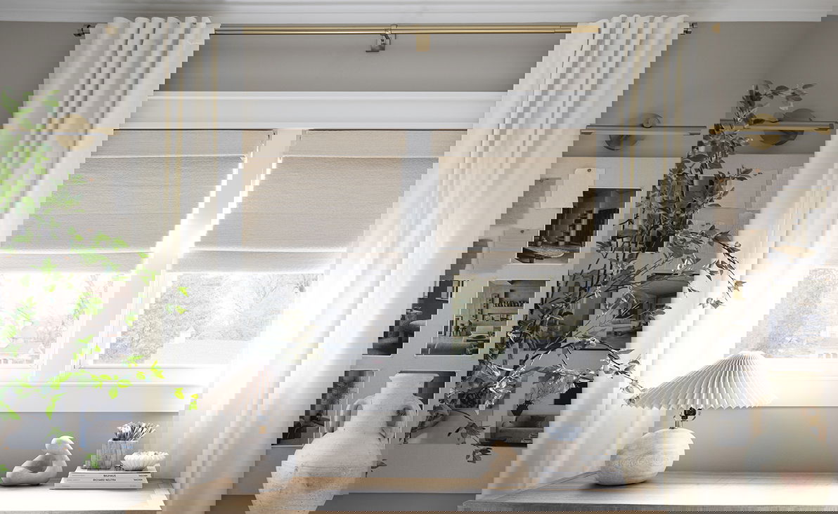 Bright and minimalist home office featuring natural woven wood shades layered with with soft white drapery on gold curtain rods. Bright and minimalist home office featuring natural woven wood shades layered with with soft white drapery on gold curtain rods.
