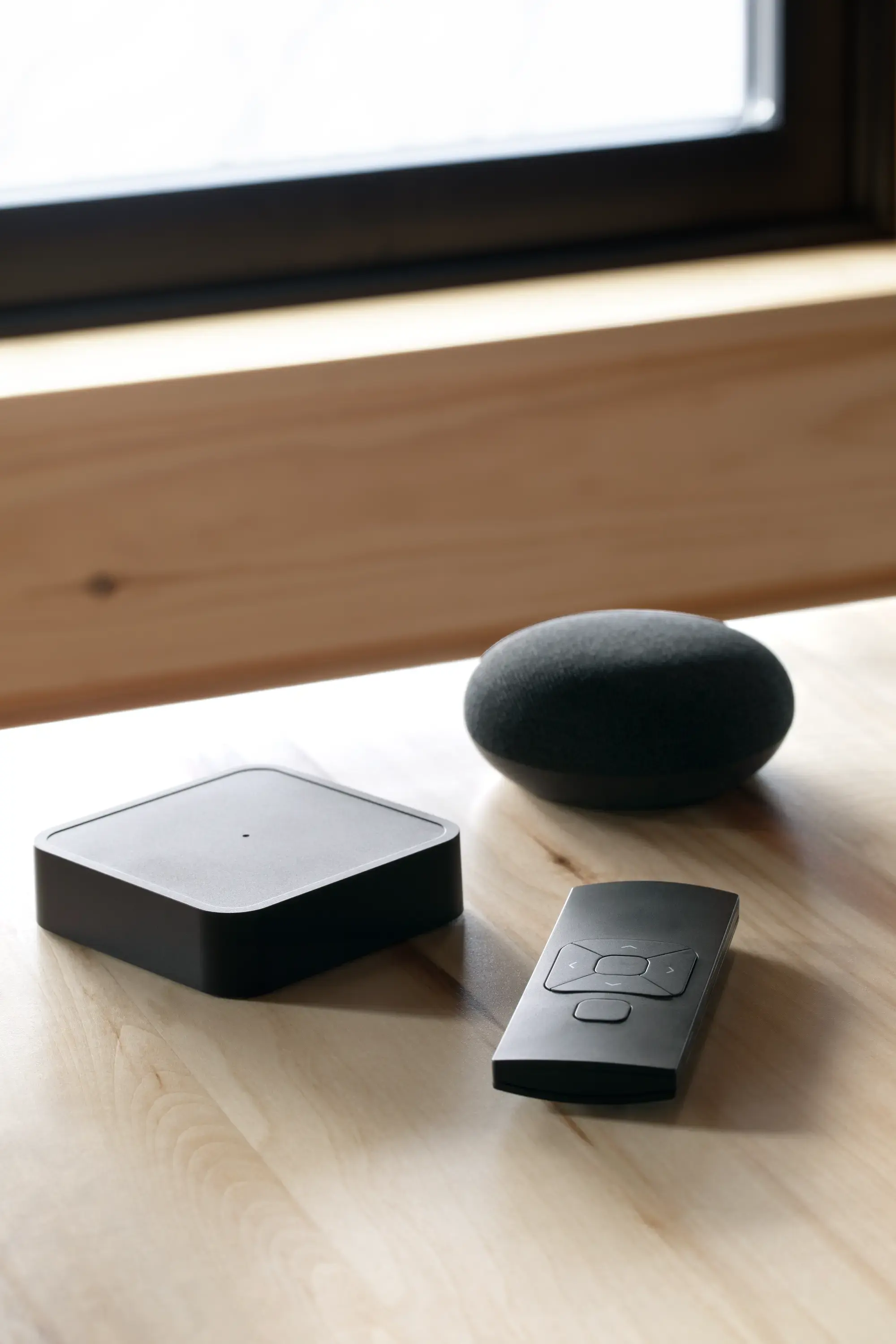 Motorization hub, remote and smart speaker on a wooden table