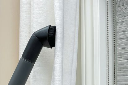 A vacuum attachment is used to clean curtains A vacuum attachment is used to clean curtains