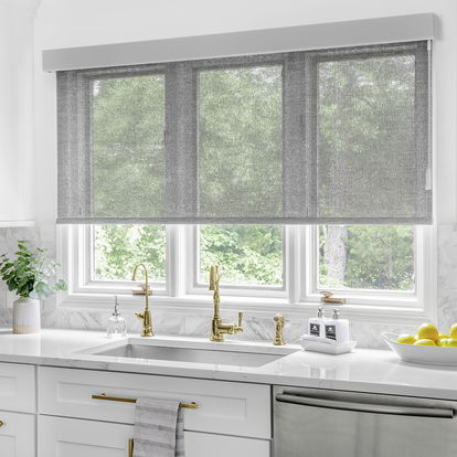 Outside mount solar roller shades cover a large window in a modern kitchen. Outside mount solar roller shades cover a large window in a modern kitchen.