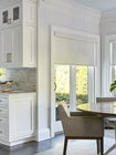 Dining area with white roller shades on windows
