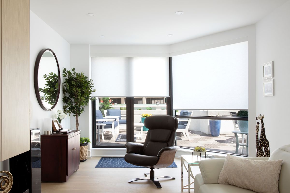 Roller shades cover glass windows in a modern waterfront living room. Roller shades cover glass windows in a modern waterfront living room.