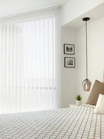 Vertical sheers offer daytime privacy without restricting the view on a large window in a modern bedroom