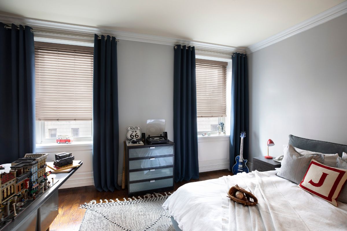 Real wood blinds paired with blue velvet drapery in a child